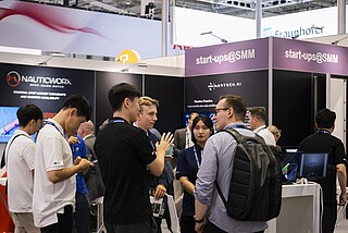 Ausstellende und Besucher unterhalten sich im Start-up Bereich.