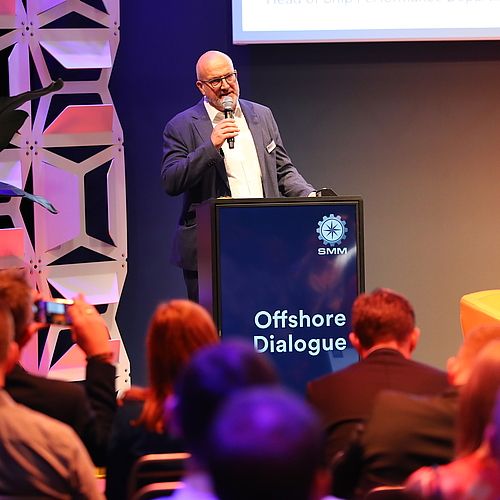 Ein Speaker spricht auf der Bühne des SMM Offshore Dialogue Kongress vor einem Publikum.