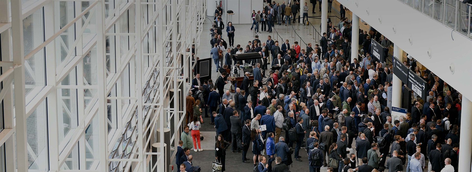 Top view of a big group of fair visitors inside the Hamburg Messe building.