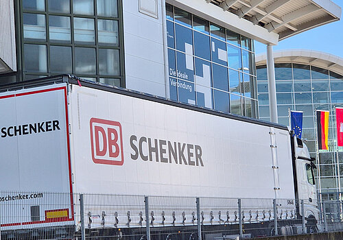 Truck with the inscription "DB Schenker" in front of the exhibition halls