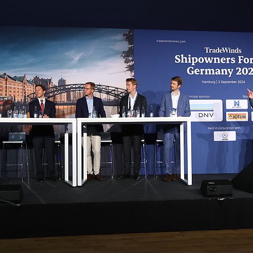 Sechs Speaker sprechen miteinander auf der TradeWinds Konferenz-Bühne. 